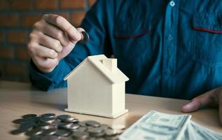 Men are putting coins together with the idea of collecting money to buy a new house. photo