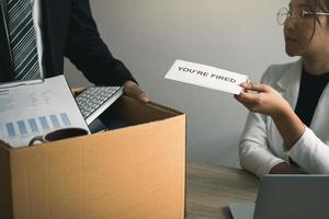 Female manager submits a resignation letter or envelope to the male employee at the office. photo