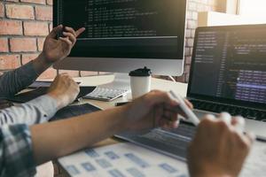 dos desarrolladores de software están usando computadoras para trabajar junto con su socio en el escritorio de la oficina. foto