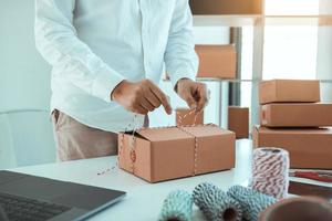 Young asian teenage product owners are packing small business packaging products in boxes prepared for shipping. photo