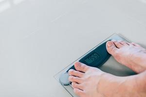 Close up of people feet standing on scale weighing. photo