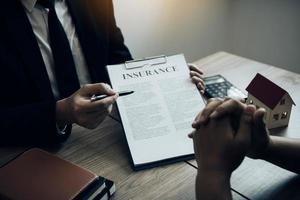 Agents are using pens pointing to insurance contracts and are being explained to customers at the office. photo