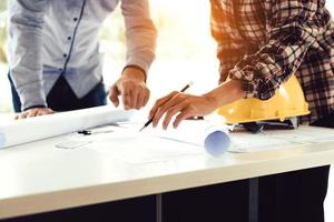 Team architect or engineering people standing working on table together at a construction site. photo