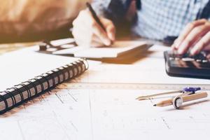 Architect engineer man calculate building area with equipment on desk. photo