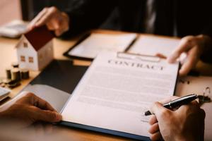 Property sales staff submit land mortgage contract documents to home buyers for sign. photo