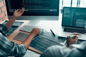 trabajando en la mañana con hombres de negocios están tomando café que trabaja con desarrolladores de software para analizar juntos el código escrito en el programa en la computadora. foto