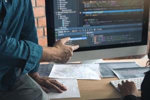 Developing programming and coding technologies working in a software engineers developing applications together in office. photo