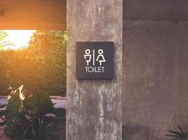 Unisex restroom or toilet label on concrete post. photo