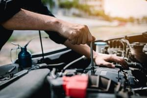 Car mechanic is holding a wrench ready to check the engine and maintenance. photo