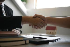 Home sales agents and buyers work on signing new homes and shaking hands. photo