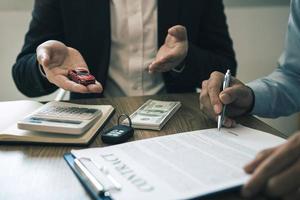 Sales car agent explains about the contract to buy a new car to the customer and the payment of installments. photo