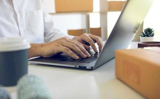 Entrepreneurs are working on taking orders of customers products by typing information tpying keyboard laptop computer in office room. photo