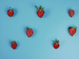 fresh strawberry slices on blue background. flat lay photo