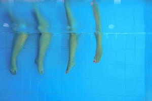 two people legs underwater in the swimming pool. Party. Summer. Vacation, diversity, friendship and sport concept. photo