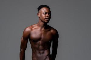 Waist up studio portrait of shirtless young lean fit African man in isolated light gray background photo