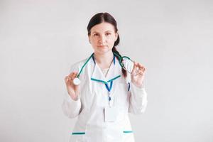 Woman doctor with a stethoscope in his hands on a white background. Copy, empty space for text photo