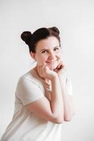 Beautiful woman with pigtails and a funny face wearing a T-shirt on a white background. Copy, empty space photo