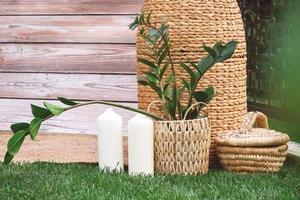 Rustic decorated with wooden background, hay, wicker pots with plants, lamps and candles. Copy, empty space for text photo