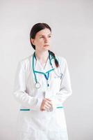 Woman doctor with a stethoscope and coat on a white background. Copy, empty space for text photo