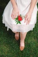 Boutonniere for wedding in the hands of a girl bride in a white dress. Copy, empty space for text photo