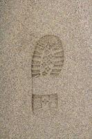 Footprint from a shoe on a sandy surface photo