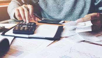 Man using calculator and calculate bills in home office. photo