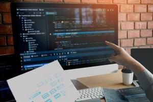 Man hands pointing coding html and programming develop on screen computer. photo