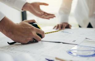 arquitectos o ingenieros trabajando con planos y discutiendo proyectos juntos en la reunión en la oficina. foto