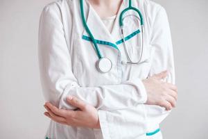 Woman doctor with a stethoscope on the neck and arms crossed on a white background. Copy, empty space for text photo