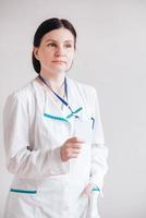 Woman doctor in a white coat holding a empty blank badge photo