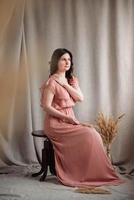 Woman in a pink dress on a background of linen fabric photo