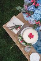 White wedding cake decorated by flowers standing of festive table. Top view. Copy, empty space for text photo