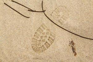 Footprint from a shoe on a sandy surface photo