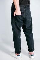 Back pocket of black jeans. Man s hand in the back pocket of jeans. Copy, empty space for text photo