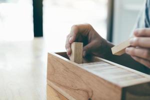 adolescente recoja sus bloques de madera en la caja. foto