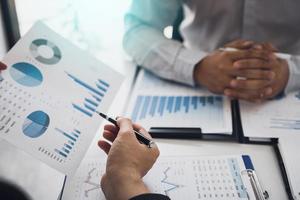 Two business partnership coworkers analysis cost work progress and gesturing with discussing a financial planning graph and company financial during a budget meeting in office room. photo