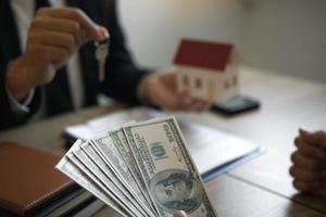 Businessman handed the house model and new homeowner giving money to real estate trading. photo