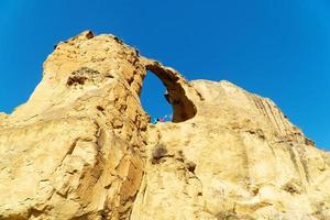 A girl makes a greeting with her hand from the top of the ring mountain in the Caucasus, a panorama from below photo