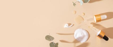 banner con pipetas y frotis y gotas de varios productos cosméticos vista superior sobre fondo beige con espacio de copia foto