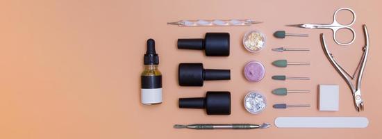 Top view tools and materials for manicure flat lay with copy space in banner format. Knolling on color background with copy space photo