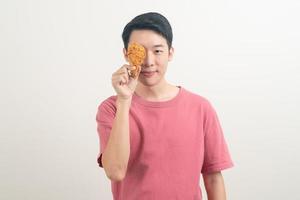 young Asian man with fried chicken on hand photo