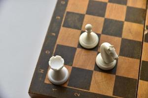 An old chessboard with white and black pieces photo