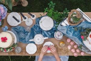 Mesa de postres para banquete decorada en estilo rústico decorada con platos, cubiertos, vasos, velas y arreglos florales. vista superior. copiar, espacio vacío para texto foto
