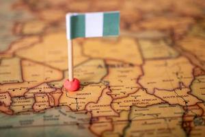 Nigeria flag with a globe map as a background macro photo