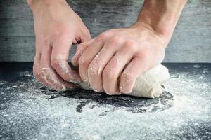 man kneads dough with his hands