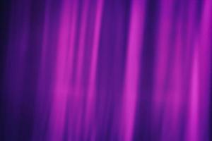 Softly blurred rays of magenta color on a dark purple background. Abstraction curtain. photo