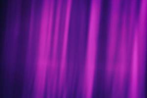 Softly blurred rays of magenta color on a dark purple background. Abstraction curtain. photo