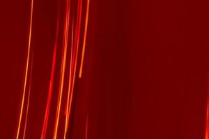 rayos de líneas rojas brillantes sobre un fondo burdeos. telón de fondo abstracto con desenfoque suave. foto
