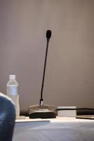 the microphones in front meeting room and bottle of water on table photo