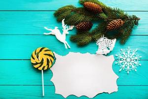 Frame of pine cones on a Christmas tree on blue wooden background. Top view photo